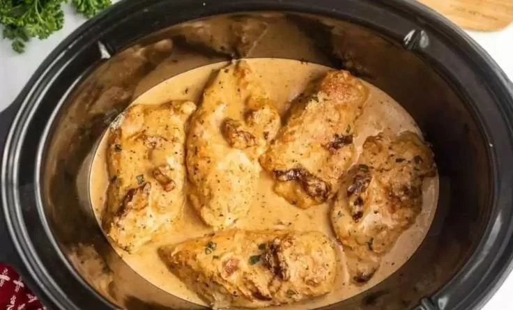 Creamy Crockpot Marry Me Chicken served with fresh herbs on a plate