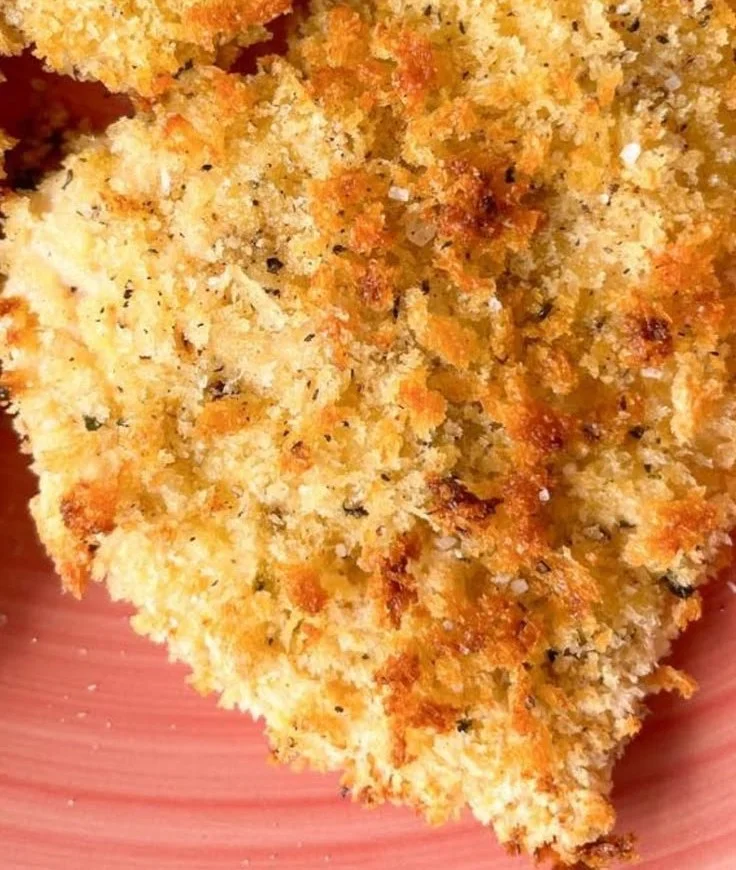 Crispy panko breaded chicken garnished with herbs on a plate