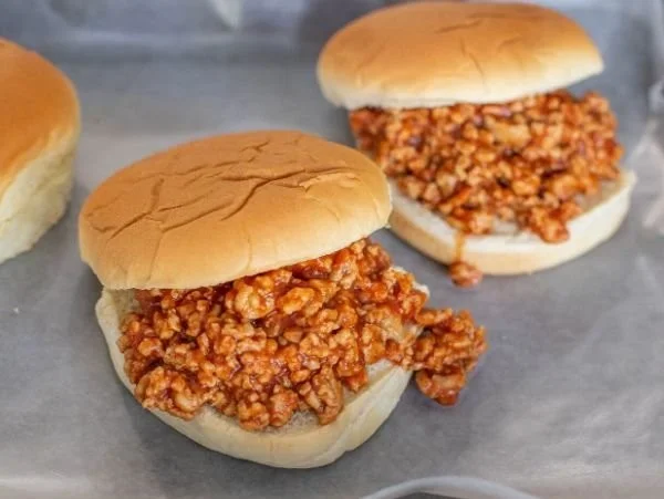 Ground chicken sloppy joes served on a bun with a side of coleslaw